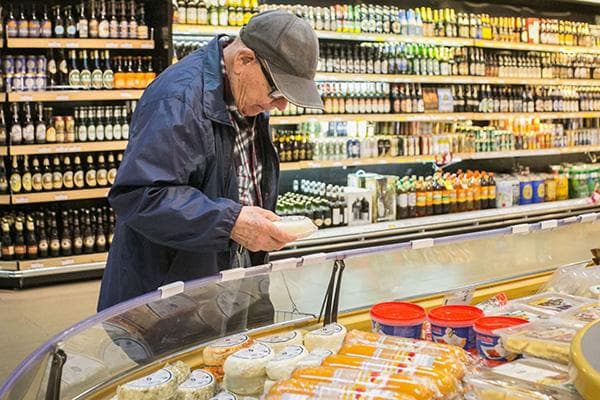 Ein Mann wählt Käse im Hypermakrt aus