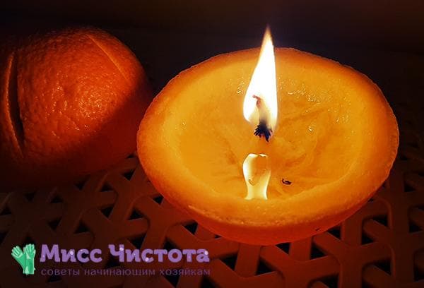 Angezündete Kerze aus einer Orangenschale