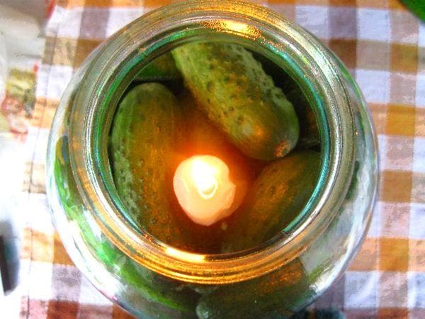 Frische Gurken im Glas mit einer Kerze