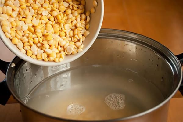 Hinzufügen von gespaltenen Erbsen in den Topf