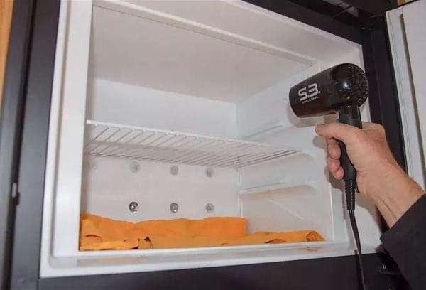 Abtauen des Kühlschranks mit einem Föhn