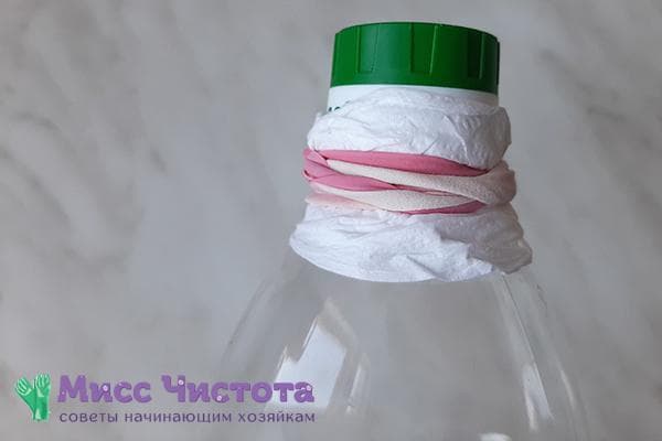 Serviette en papier sur le goulot d'une bouteille d'huile