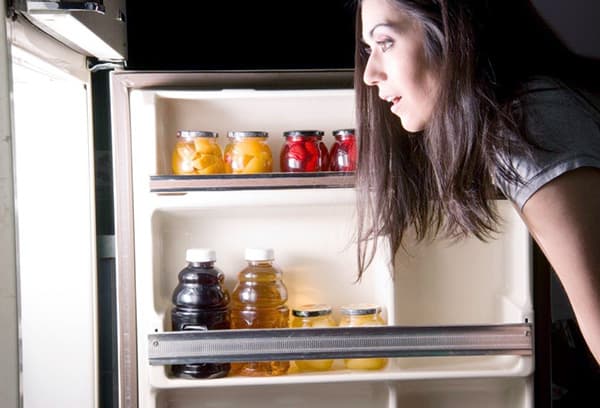 Eine Frau öffnet den Kühlschrank