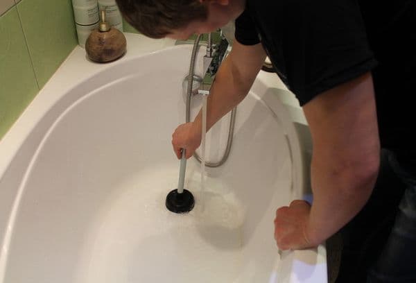 Reinigung des Abflusses der Badewanne mit einer Saugglocke