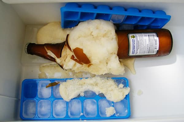 Zerbrochene Flasche mit gefrorenem Bier