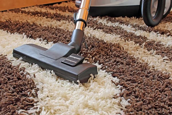 Behandlung des Teppichs mit einem Staubsauger