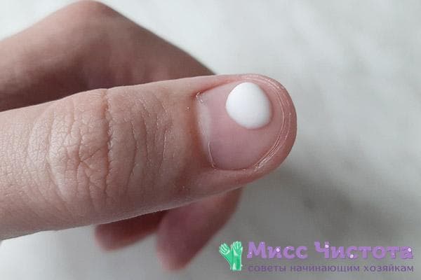 Milchtropfen auf dem Fingernagel