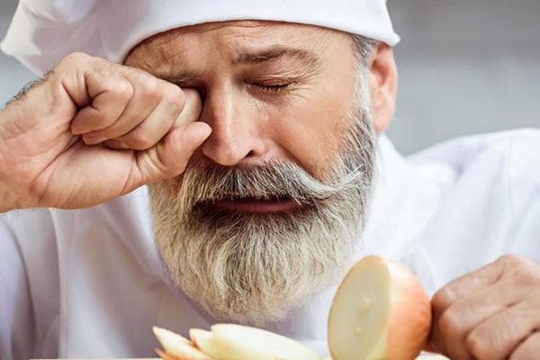 Ein Koch weint wegen der Zwiebel