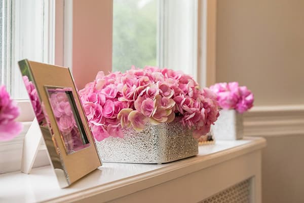 Box mit künstlichen Blumen auf der Fensterbank