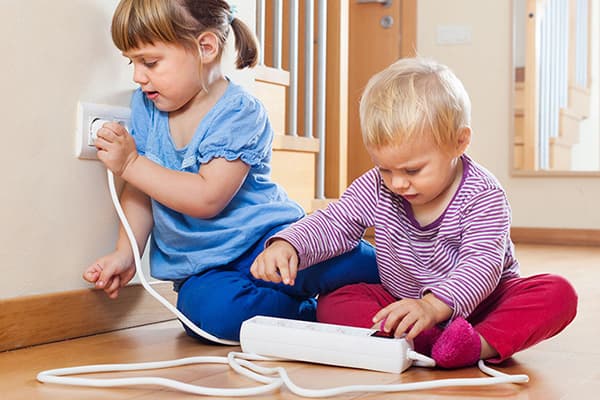 Kinder spielen mit einer Steckerleiste