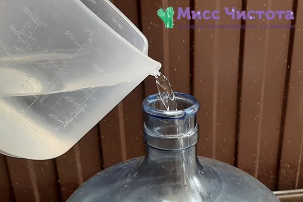 Versement de la solution de bicarbonate dans une bonbonne de 19 litres