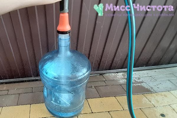 Rinçage d'une bonbonne de 19 litres à l'eau du tuyau