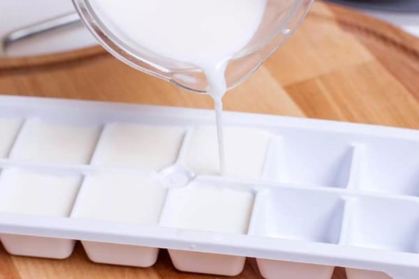 Abfüllen von Milch in Eiswürfelformen