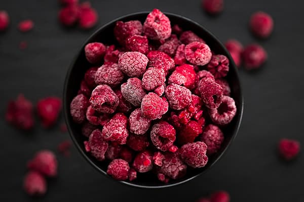 Schale mit gefrorenen Himbeeren