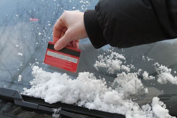 Auto von Schnee befreien mit einer Plastikkarte