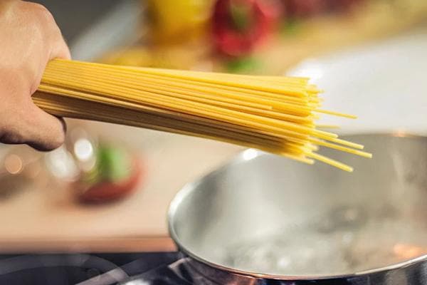 Spaghetti und ein Topf mit kochendem Wasser