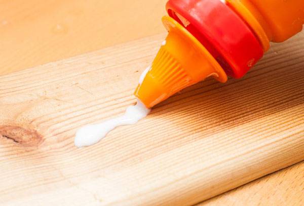 Auftragen von Kleber auf eine Holzleiste