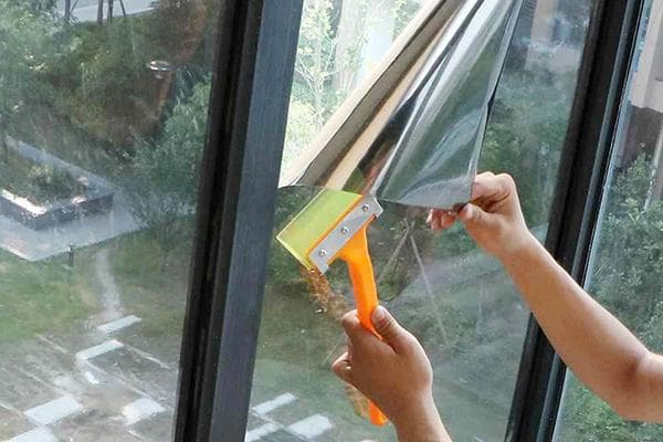 Aufkleben der reflektierenden Folie auf das Fenster