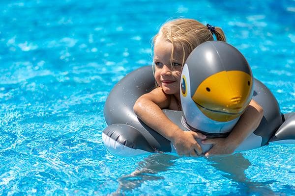 Mädchen mit Schwimmreifen im Pool
