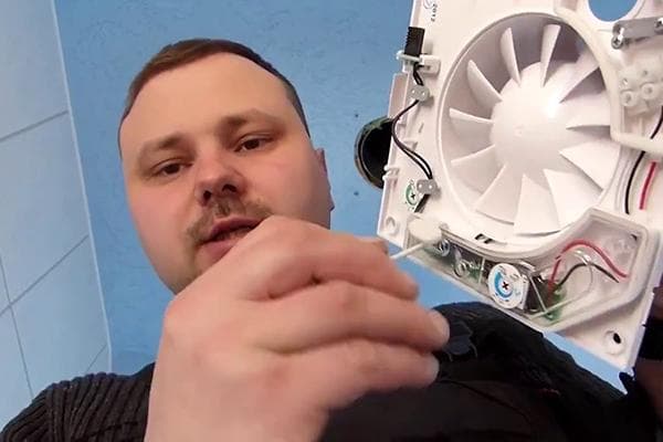 Ein Mann repariert einen Abluftventilator