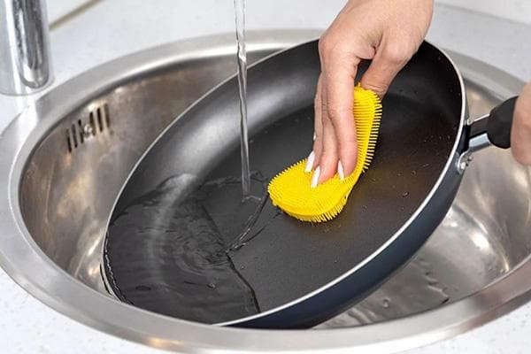 Reinigen einer Pfanne mit einem Silikonschwamm