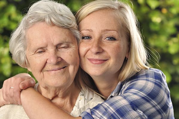 Eine Frau umarmt ihre Mutter