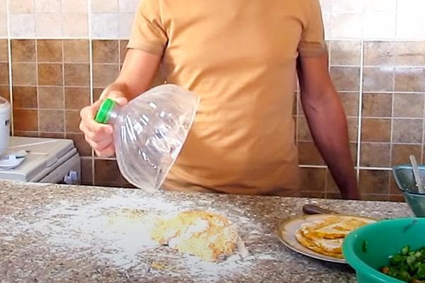 Ein Mann deckt Teig mit der Oberseite eines Plastikbehälters ab