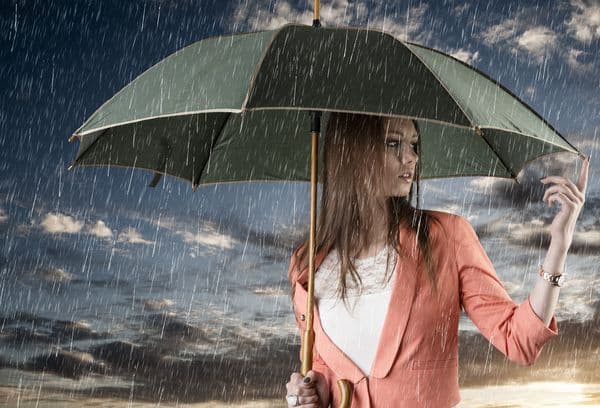 Frau mit Regenschirm im Regen