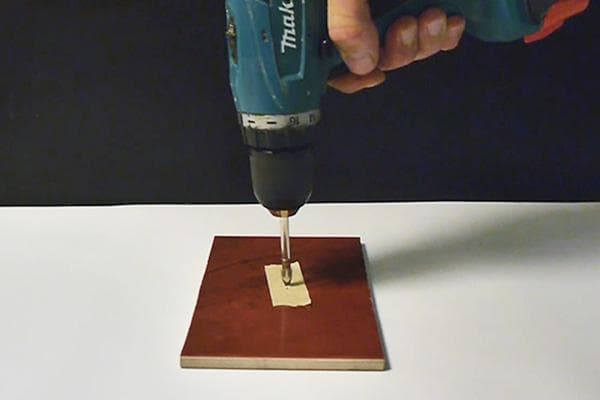 4. Rutschfeste Unterlage aus Malerkrepp beim Bohren von Spanplatten