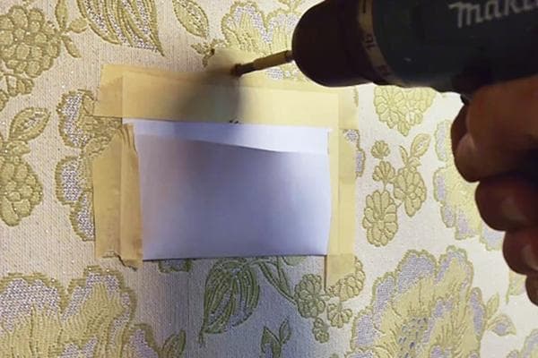 Verwendung einer Papiertasche beim Bohren einer Wand