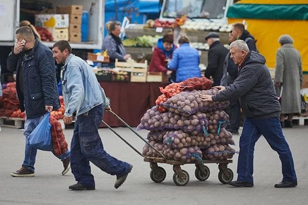 Männer transportieren Kartoffeln in Säcken