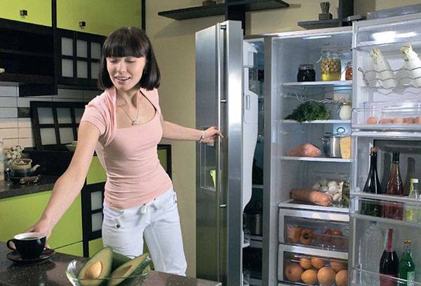 Eine Frau holt Lebensmittel aus dem Kühlschrank