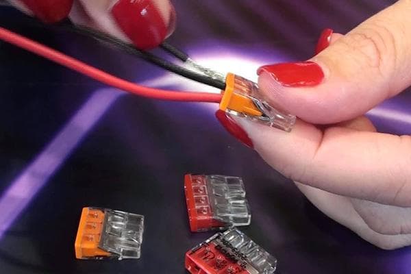 Frau verbindet Kabel mit einer Klemme
