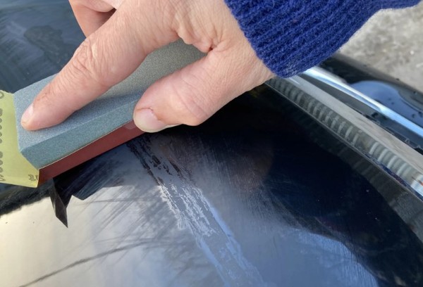 Kratzer von der Windschutzscheibe mit feinem Schleifpapier entfernen