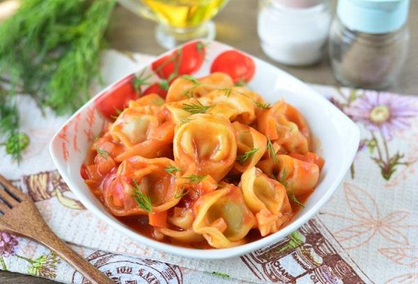 Gebratene Pelmeni mit Tomatenmark in der Pfanne