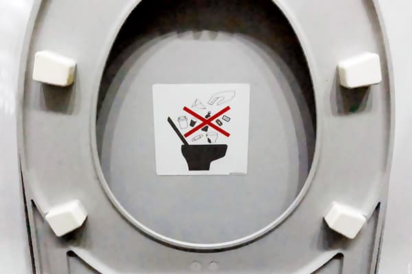 Aufkleber, der das Werfen von Müll in die Toilette verbietet