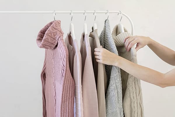Frau wählt einen Pullover