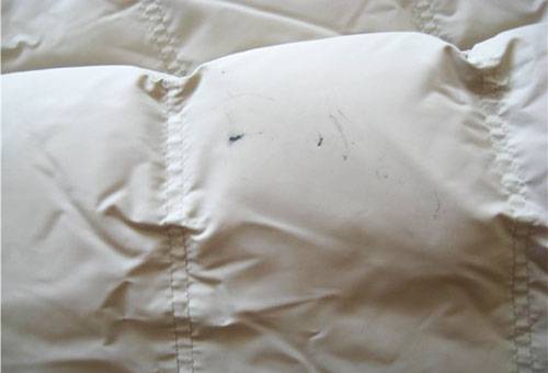 Verschmutzte weiße Daunenjacke