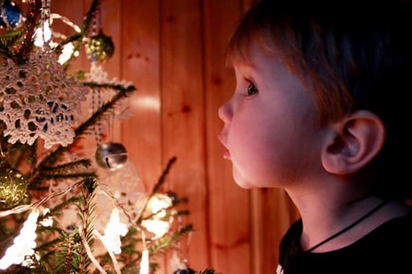Kind neben dem Weihnachtsbaum
