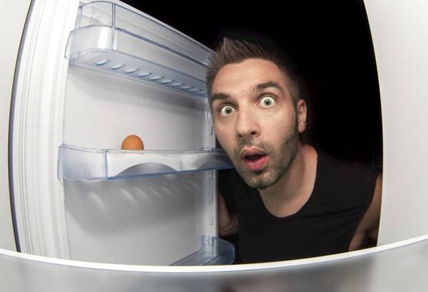 Ein Mann schaut in den Kühlschrank