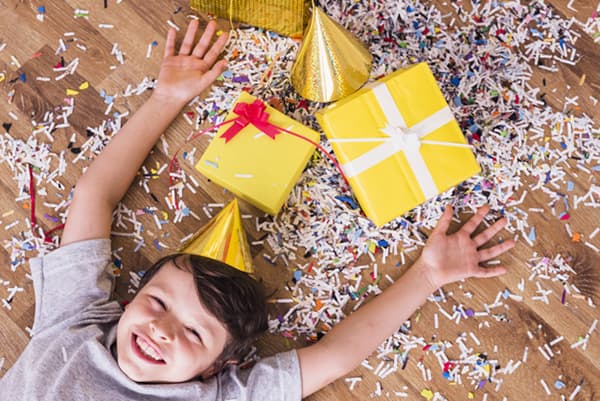 Kind mit Geschenken und Konfetti