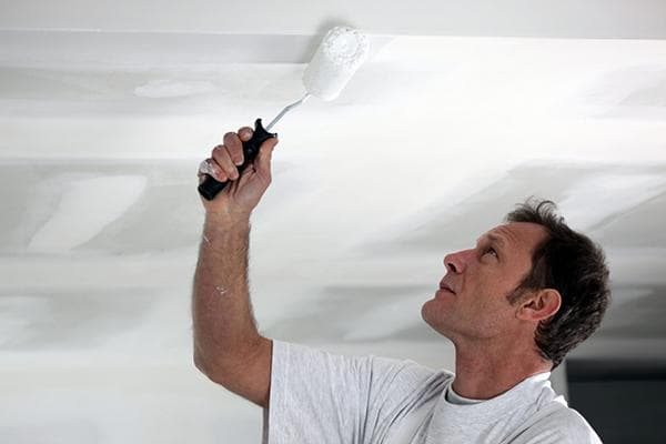 Ein Mann streicht die Decke
