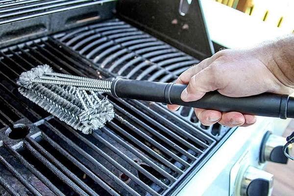 Ein Mann reinigt den Grill