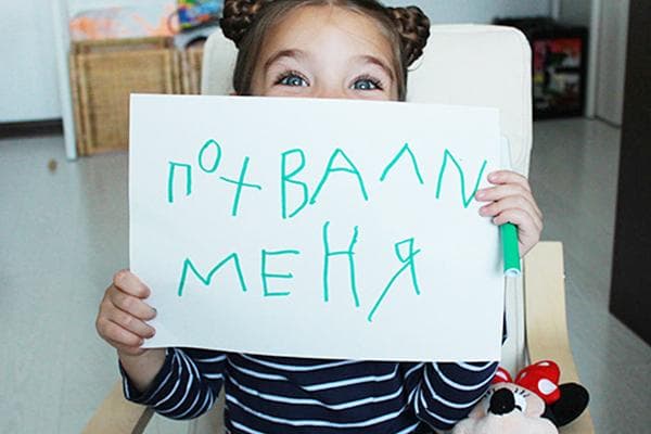 Mädchen mit einem Plakat „Lobe mich“