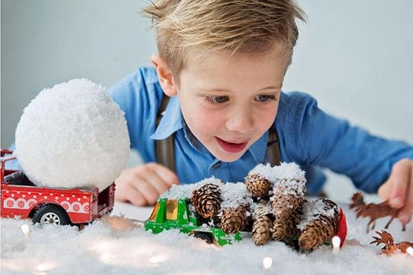 Ein Junge spielt mit künstlichem Schnee