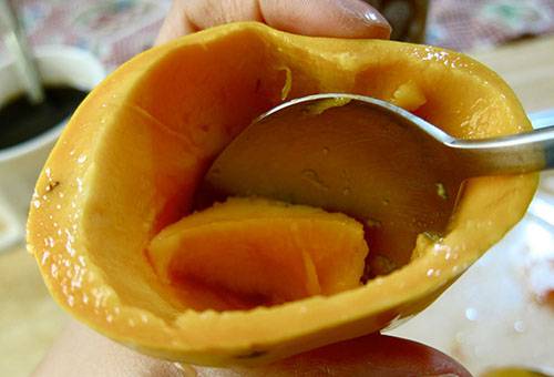 Entnehmen des Mangofruchtfleischs mit einem Löffel