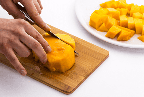 Schneiden der Mango in Würfel für den Salat