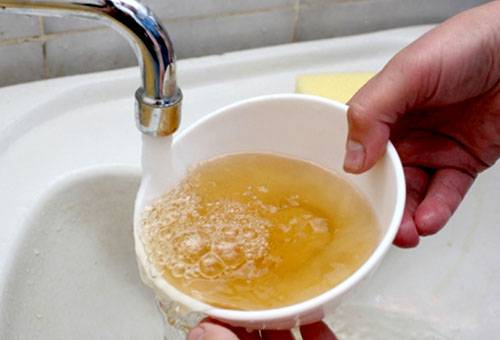 Schmutziges rostiges Wasser aus dem Wasserhahn