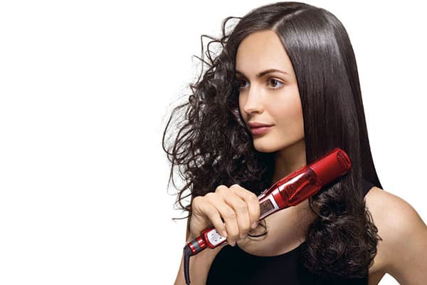 Eine Frau glättet ihre Haare