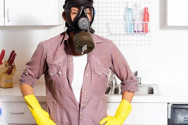 Mann mit Gasmaske in der Küche
